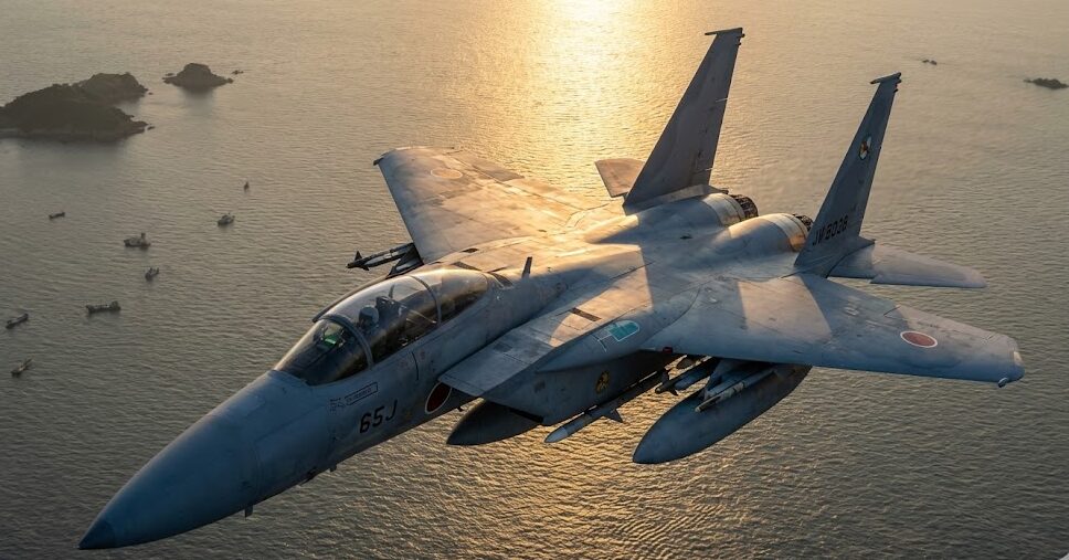 航空自衛隊F-15J戦闘機が東シナ海上空を夕日に照らされながら飛行する様子