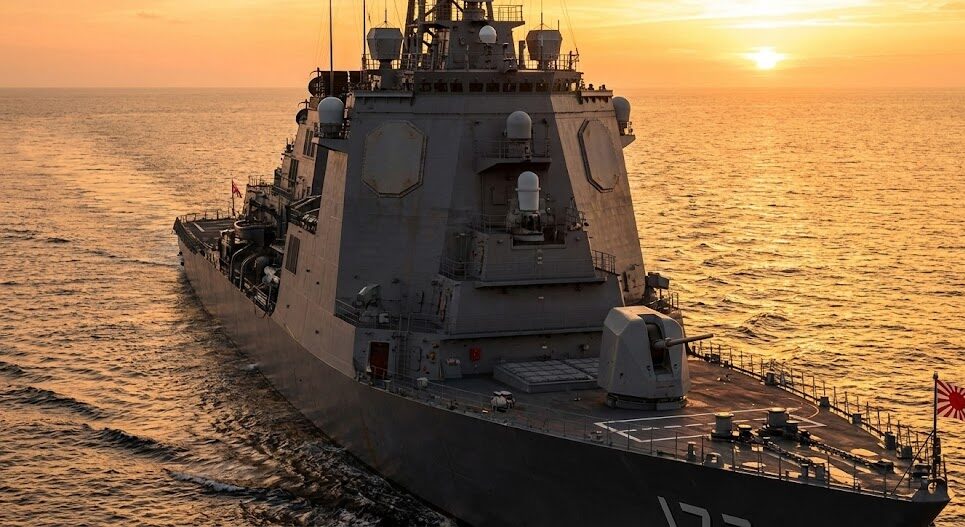 夕日の海を航行する日本のイージス護衛艦、SPYレーダーとVLSシステムが印象的