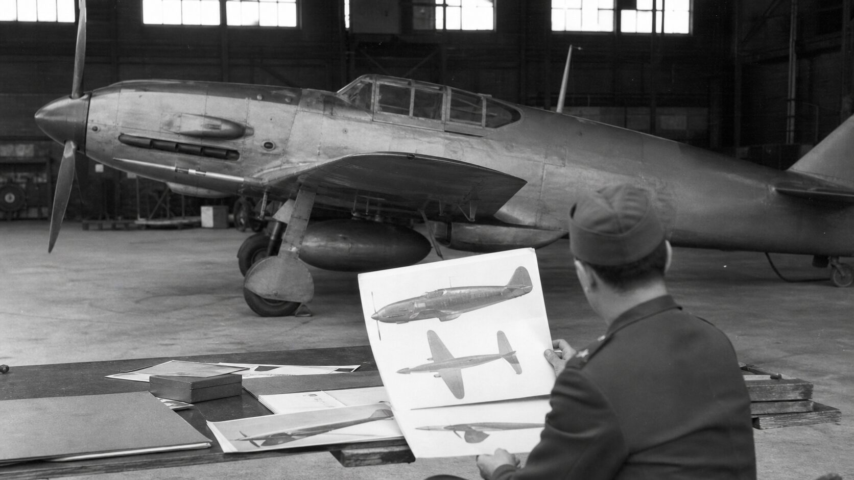 液冷エンジンの細身の戦闘機を欧州機の資料と比較する場面
