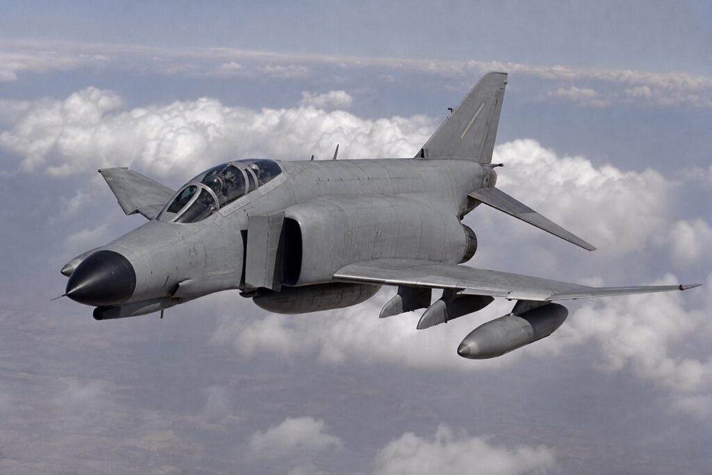 雲海上空を飛行するF-4ファントムII級の双発戦闘機