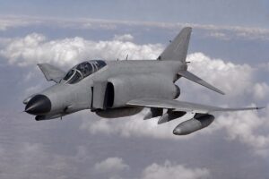 雲海上空を飛行するF-4ファントムII級の双発戦闘機