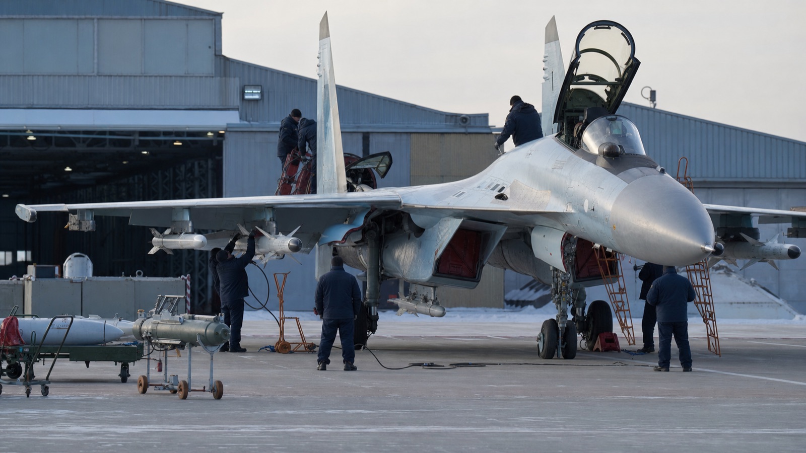 冬季飛行場でSu-35級戦闘機を点検する地上整備員