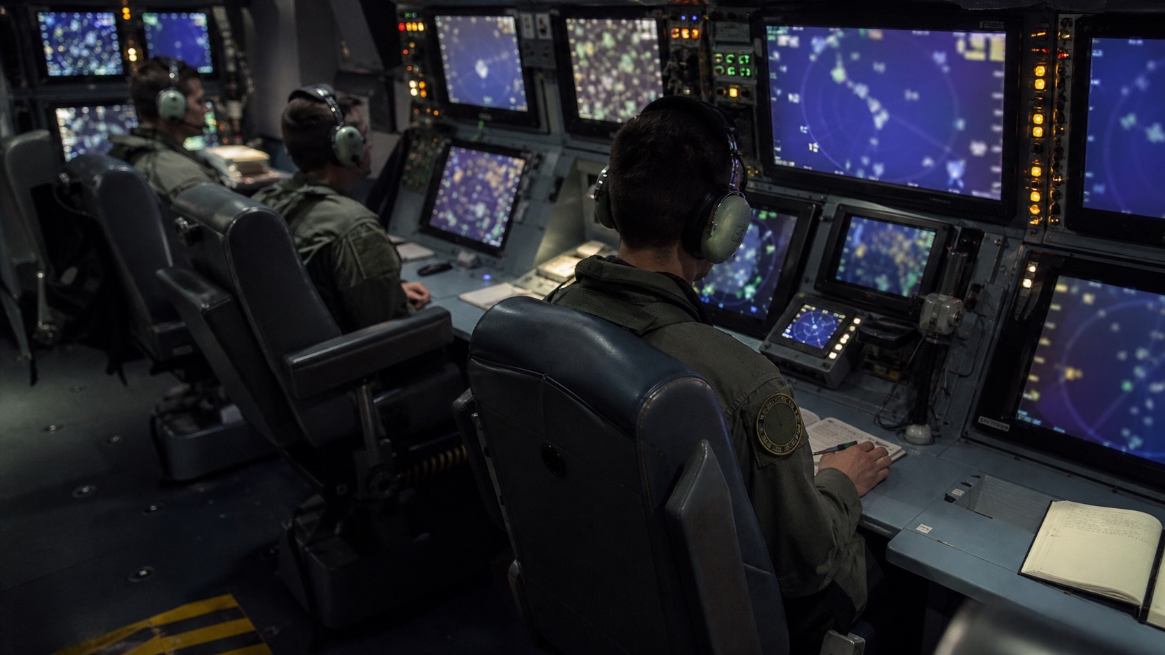 早期警戒機の任務区画で戦術情報を分析する搭乗員