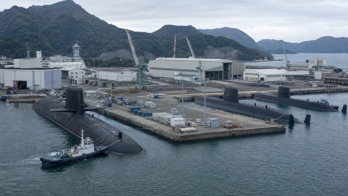 潜水艦基地で通常動力潜水艦と原子力潜水艦を整備する様子を描いた編集用イメージ