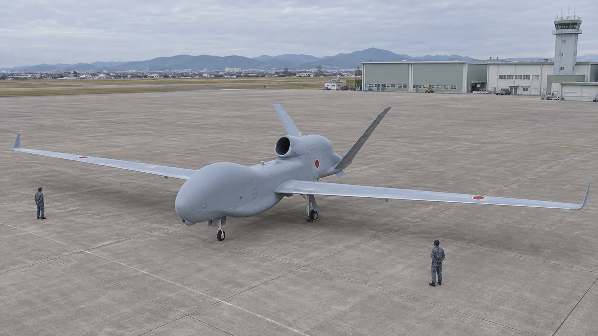 広い翼を持つRQ-4Bグローバルホークと地上の整備員