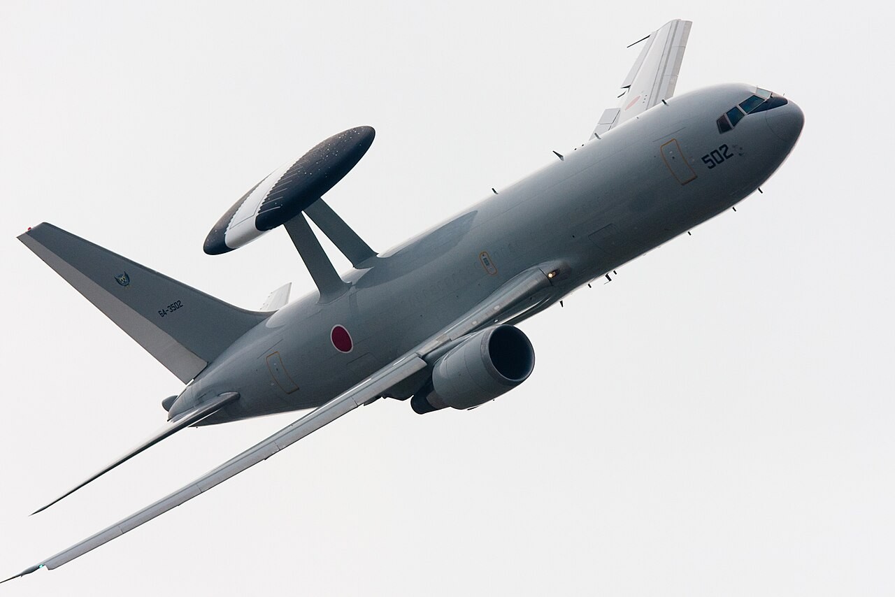 旋回する航空自衛隊E-767。胴体上部に大型のレーダードームを備える。