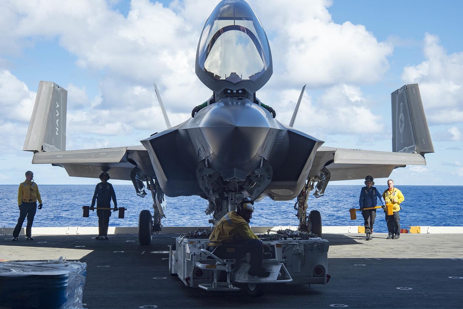 空母上のF-35C。機首の脚と、折り畳まれた主翼端が見える。