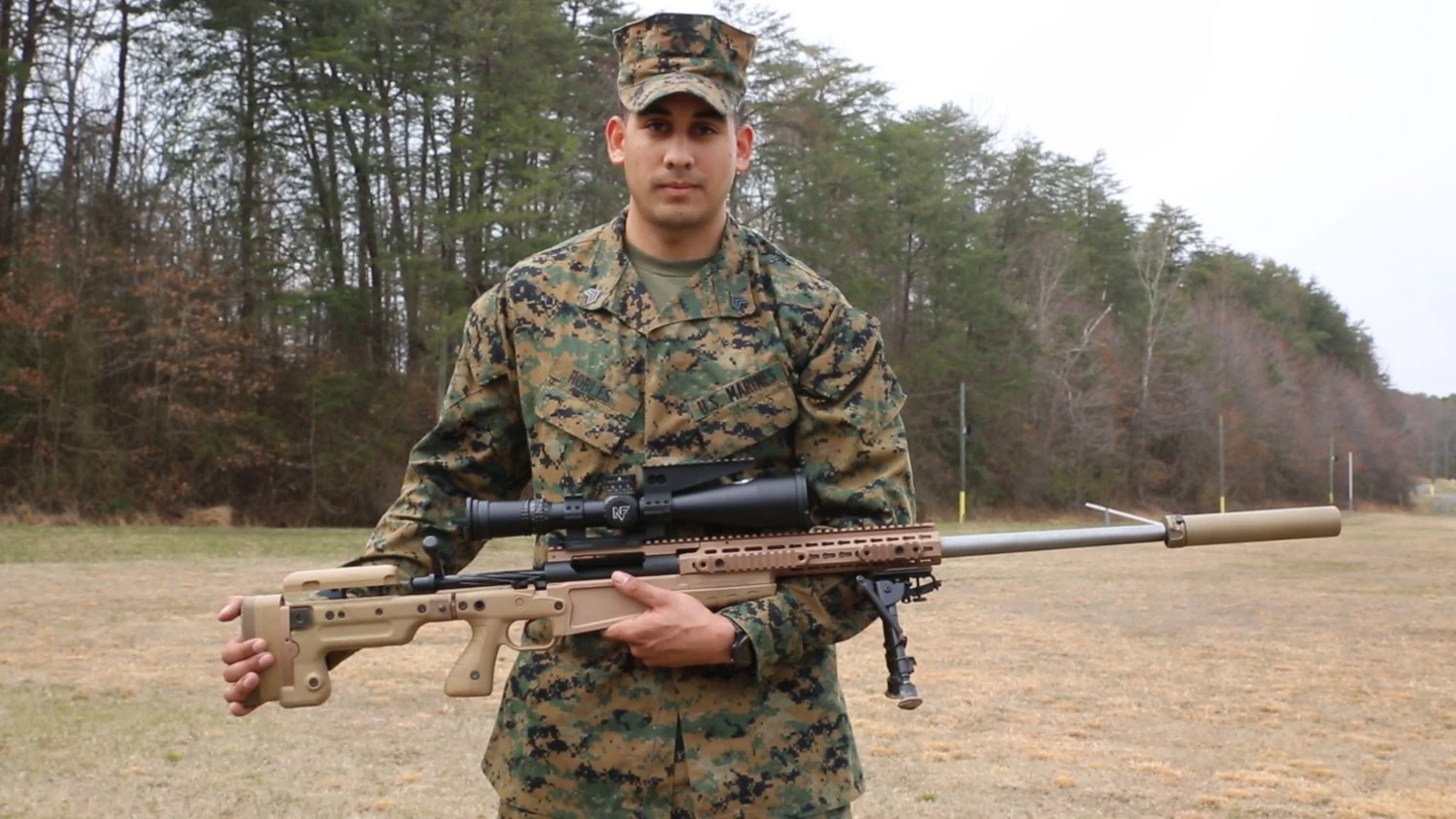 Mk13 Mod 7狙撃銃を説明する米海兵隊員。銃口側にサプレッサーを備える。