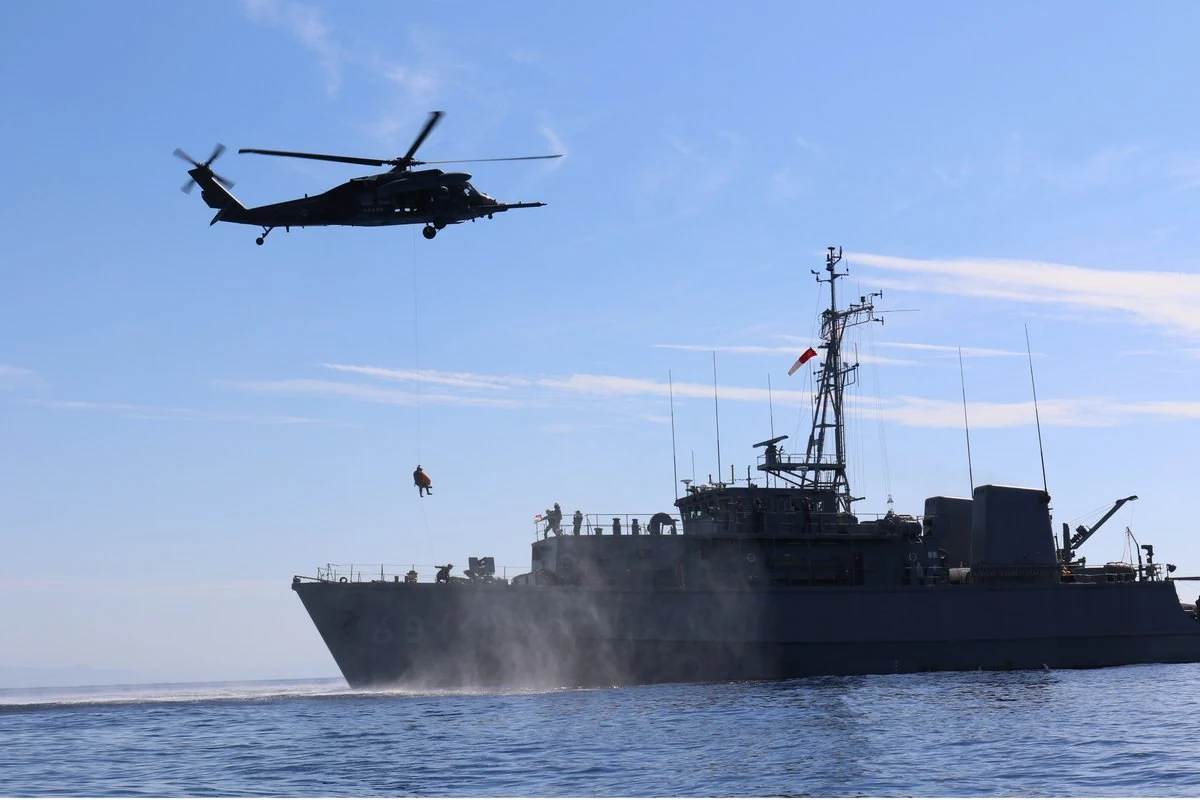 掃海艇「すがしま」から要救助者を収容する航空自衛隊のUH-60J。